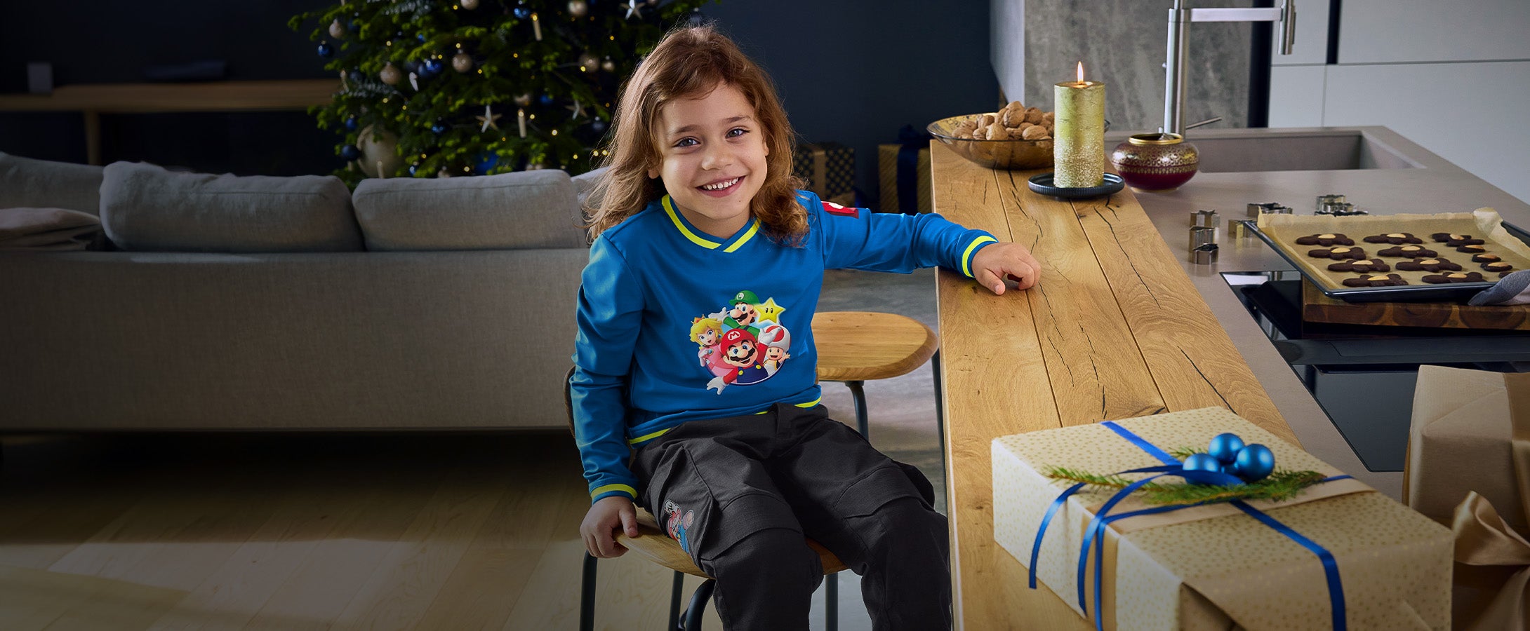 Girl wearing clothing from the Super Mario x Strauss collection in a Christmas living room